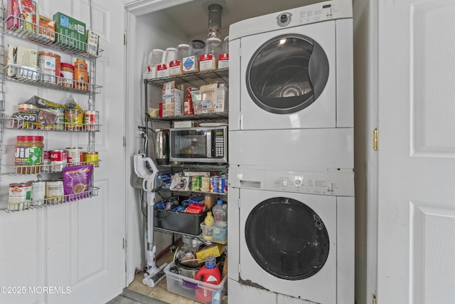 clothes washing area with stacked washing machine and dryer