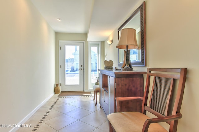 doorway to outside featuring light tile patterned floors and baseboards
