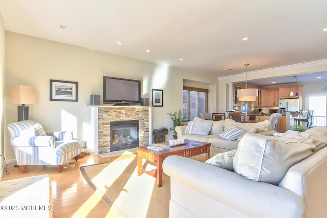 living room featuring light wood-style floors, a stone fireplace, and recessed lighting