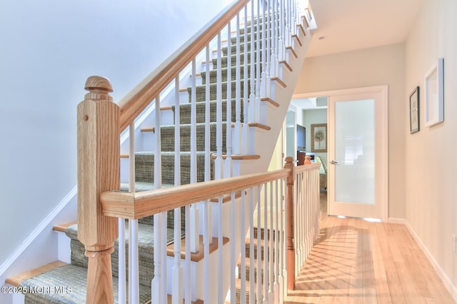 stairs with wood finished floors and baseboards