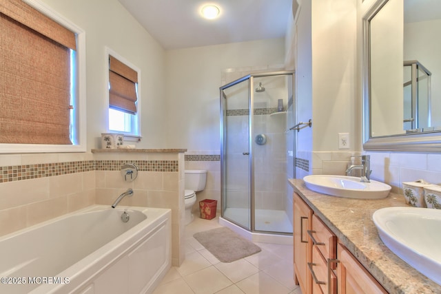 full bathroom with toilet, tile patterned floors, tile walls, a stall shower, and a garden tub