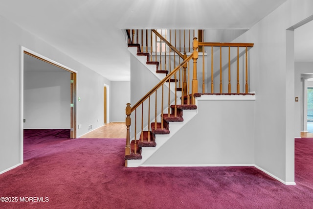 stairs featuring carpet flooring and baseboards