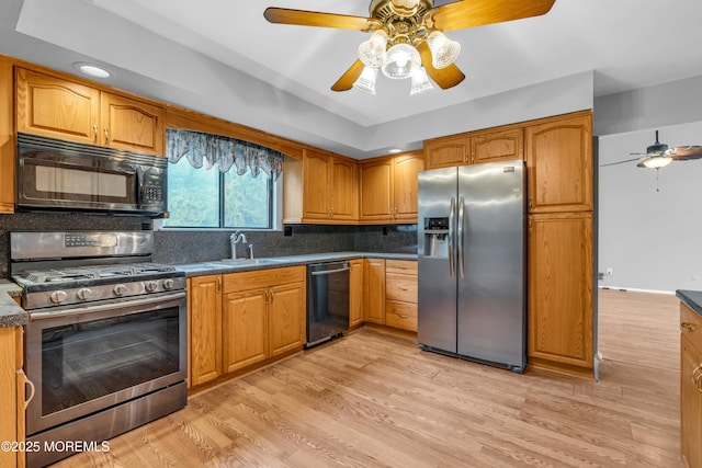kitchen featuring black appliances, ceiling fan, a sink, and brown cabinets