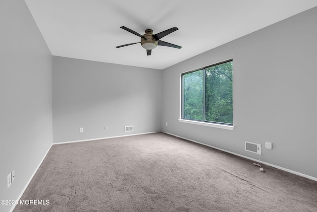 spare room featuring a ceiling fan, carpet floors, and baseboards