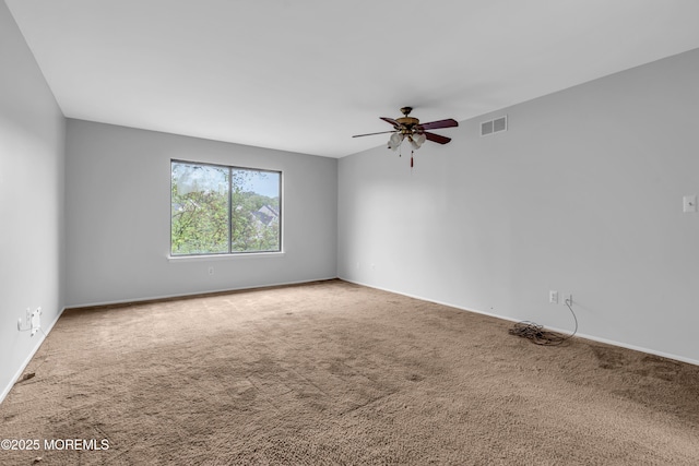 carpeted empty room with ceiling fan and baseboards