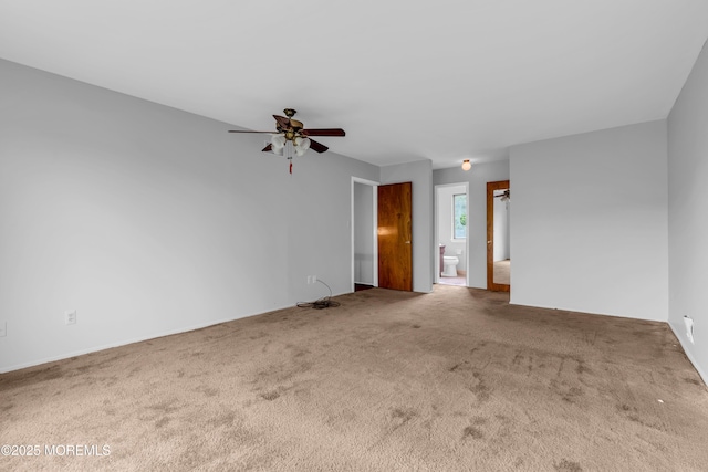carpeted spare room with a ceiling fan