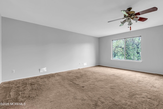 empty room featuring a ceiling fan, carpet, and baseboards