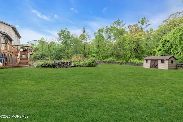 view of yard featuring a wooden deck, an outbuilding, and stairway