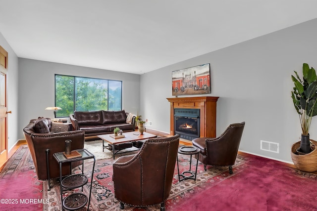 living room featuring a glass covered fireplace and baseboards