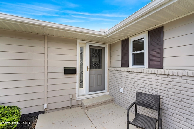 doorway to property featuring brick siding