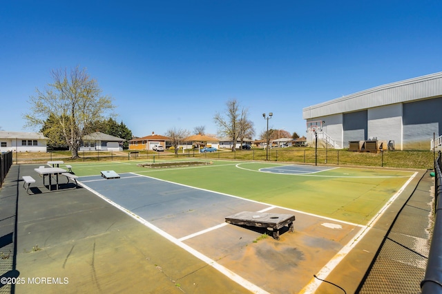 view of sport court with fence, community basketball court, and a residential view