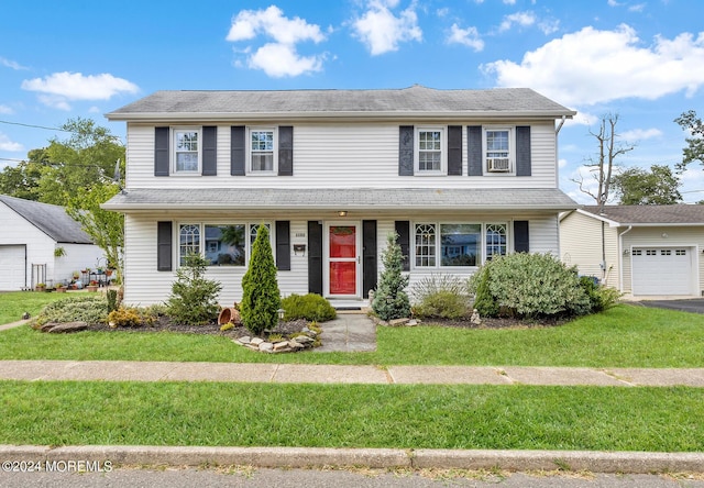 view of front of property with a front lawn, an attached garage, driveway, and cooling unit