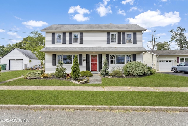 view of front of property featuring asphalt driveway, a front yard, and a garage