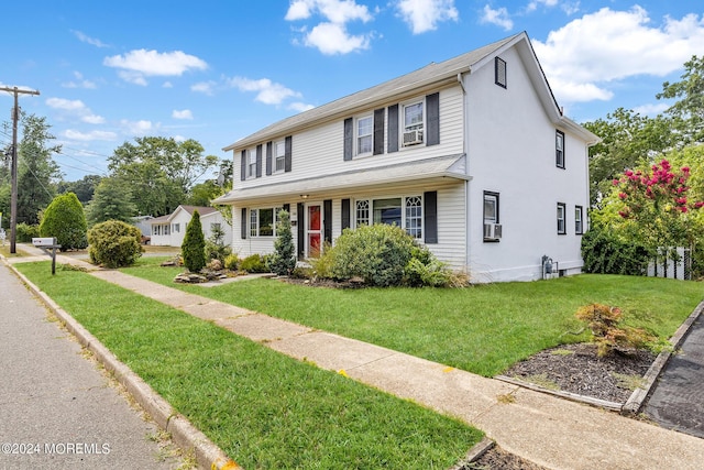 traditional-style house with a front yard and cooling unit