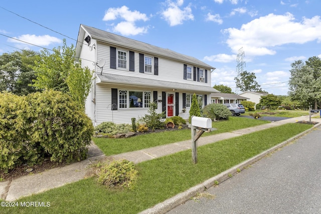 traditional-style home featuring a front lawn