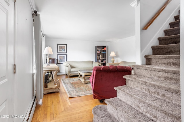 living room with stairs, light wood-style flooring, ornamental molding, a baseboard heating unit, and a baseboard radiator