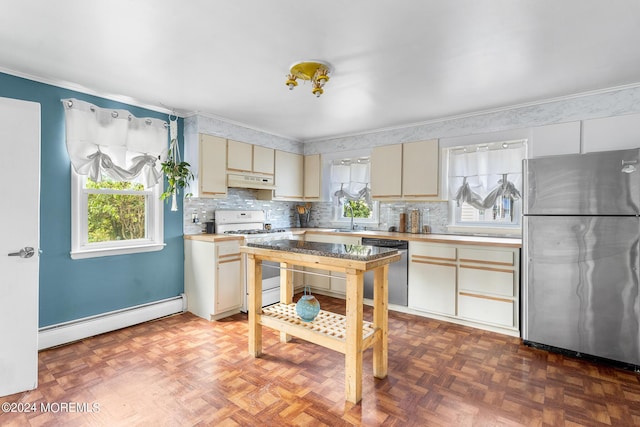 kitchen featuring appliances with stainless steel finishes, a baseboard radiator, cream cabinets, under cabinet range hood, and light countertops