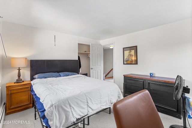 bedroom featuring light colored carpet and baseboard heating