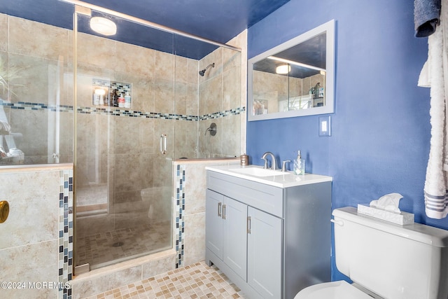 bathroom featuring a shower stall, toilet, and vanity
