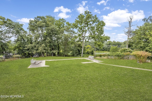 view of property's community with a yard and a patio area