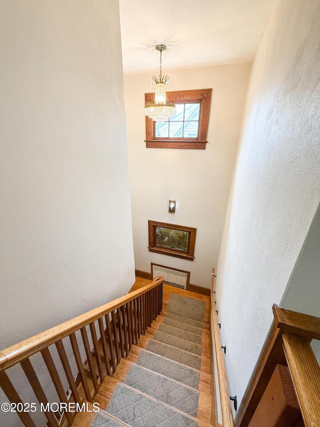 7 Dock St, Toms River, NJ 08753 - staircase with a chandelier, wood finished floors, baseboards, and a textured wall
