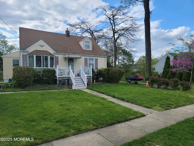 cape cod home with a front lawn, a chimney, and a shingled roof