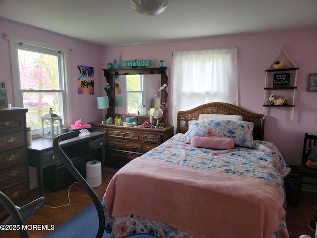 bedroom with wood finished floors and multiple windows