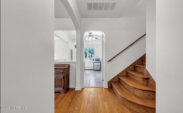 221 Harrison Ave, Oakhurst, NJ 07755 - foyer entrance featuring arched walkways, ceiling fan, light wood-type flooring, stairs, and baseboards