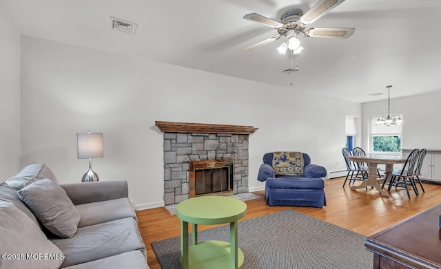 221 Harrison Ave, Oakhurst, NJ 07755 - living room featuring a baseboard heating unit, ceiling fan, wood finished floors, a fireplace, and a chandelier