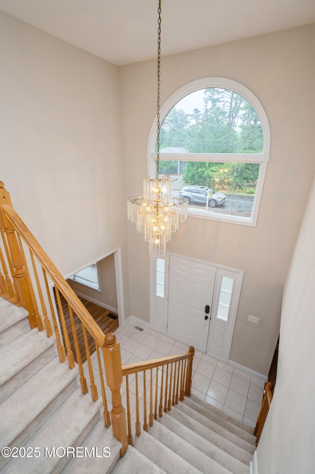 476 Birch Bark Dr, Brick, NJ 08723 - foyer with a chandelier, stairway, tile patterned flooring, a towering ceiling, and baseboards