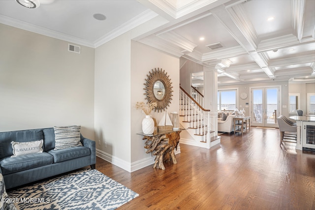 living area featuring ornamental molding, stairs, wood finished floors, ornate columns, and baseboards