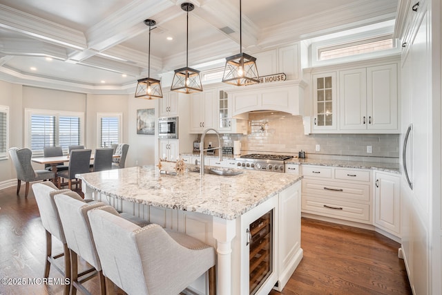 kitchen with built in appliances, a sink, backsplash, white cabinets, and coffered ceiling
