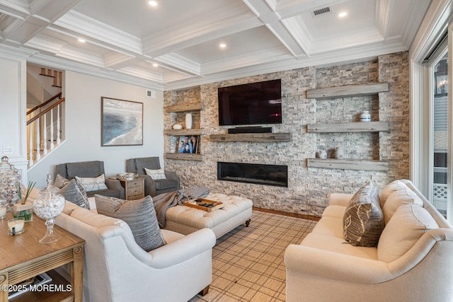 living room with coffered ceiling, beam ceiling, stairs, a stone fireplace, and ornamental molding