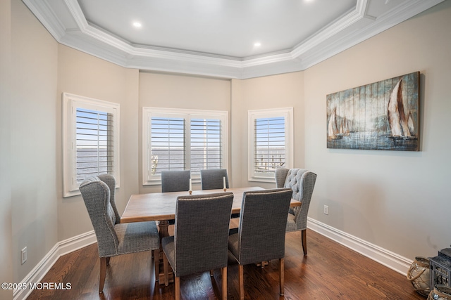dining area with crown molding, dark wood-style flooring, baseboards, a raised ceiling, and recessed lighting