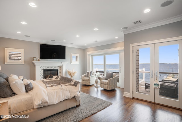 bedroom featuring access to outside, french doors, crown molding, a tile fireplace, and recessed lighting