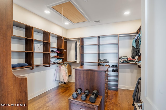 spacious closet featuring attic access and dark wood finished floors