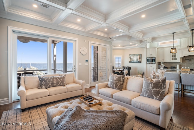 living room featuring a water view, coffered ceiling, wood finished floors, beam ceiling, and healthy amount of natural light