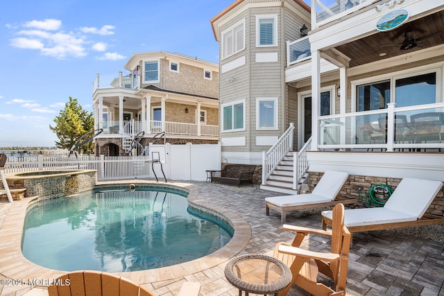 view of pool featuring a fenced backyard, a patio area, stairway, and a ceiling fan