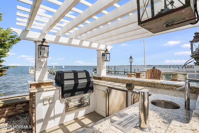 view of patio / terrace with a water view, an outdoor kitchen, a sink, and a pergola