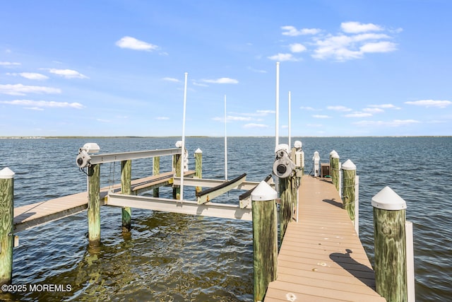 dock area featuring boat lift and a water view