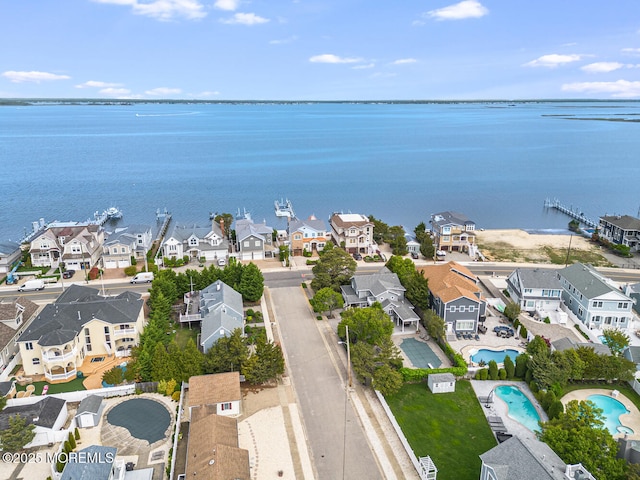 aerial perspective of suburban area with a pool and a large body of water