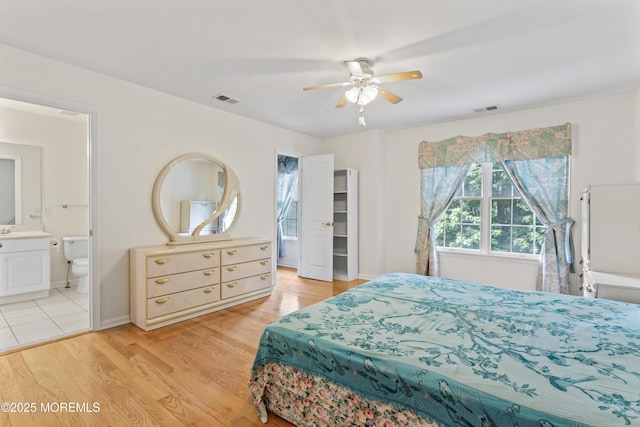 bedroom with light wood-style floors, connected bathroom, and ceiling fan