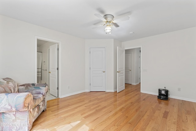 bedroom featuring light wood-type flooring, baseboards, ceiling fan, and connected bathroom