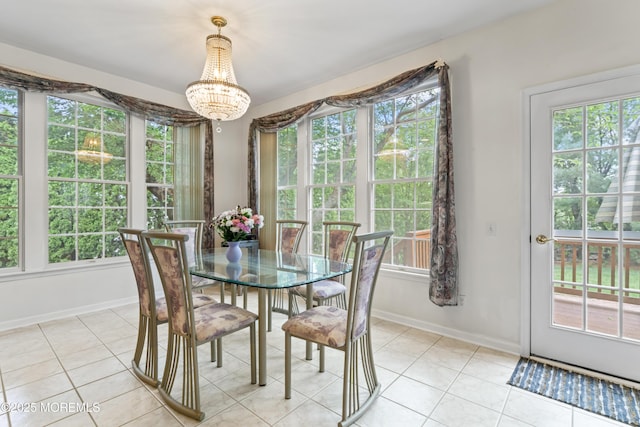 dining area featuring healthy amount of natural light, light tile patterned floors, and a chandelier