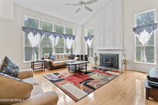 living area with high vaulted ceiling, light wood finished floors, and a ceiling fan