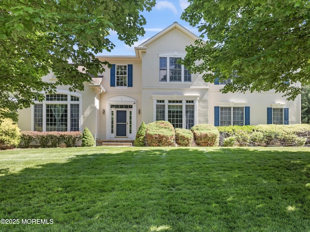 view of front of house with stucco siding and a front yard