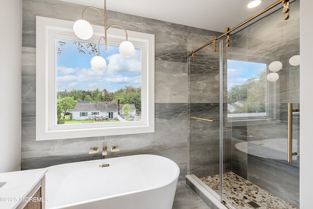 983 Cedar Grove Rd, Toms River, NJ 08753 - bathroom featuring a freestanding tub, a stall shower, plenty of natural light, vanity, and tile walls