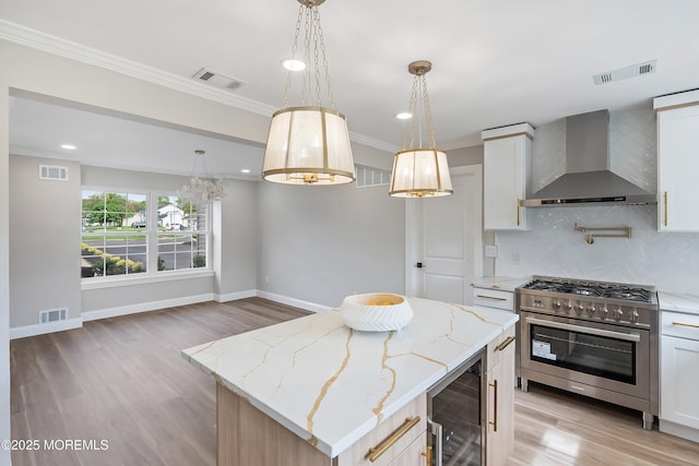 983 Cedar Grove Rd, Toms River, NJ 08753 - kitchen featuring wall chimney exhaust hood, beverage cooler, stainless steel stove, tasteful backsplash, and light wood-style flooring