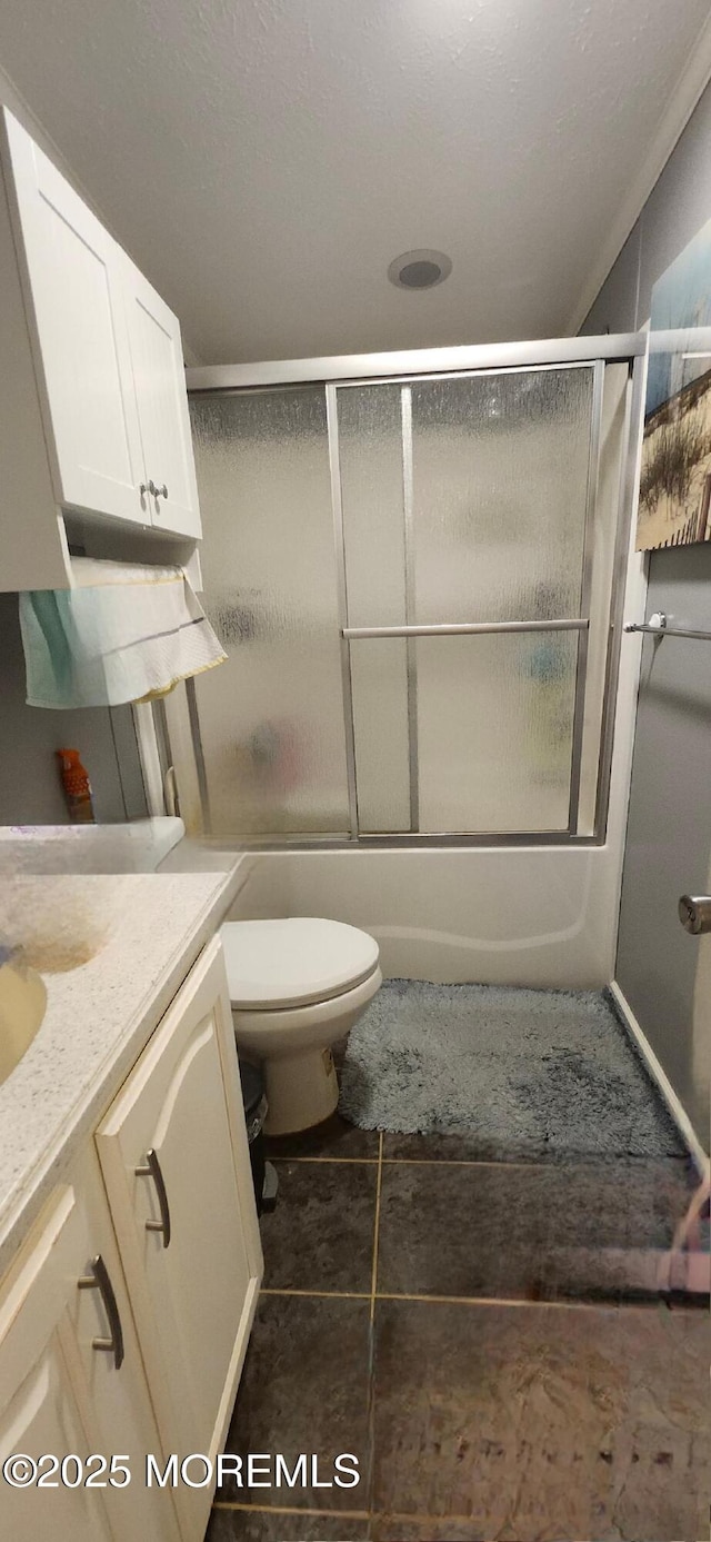 full bathroom featuring shower / bath combination with glass door, vanity, toilet, and tile patterned flooring