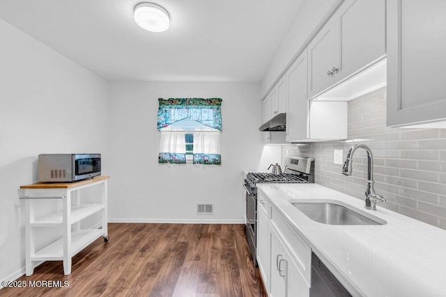 22 Orchard Ct, Howell, NJ 07731 - kitchen featuring stainless steel appliances, under cabinet range hood, a sink, decorative backsplash, and white cabinetry